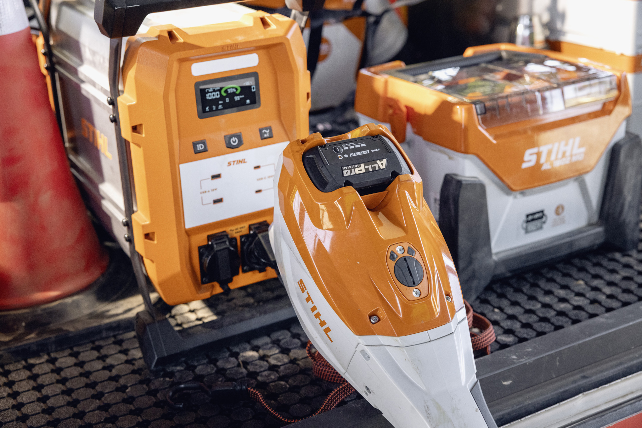Преносливиот полнач STIHL AL 1802 MO и power bank-от STIHL PS 2000 се подготвени да ги наполнат батериите ALLPRO на просторот за полнење.
