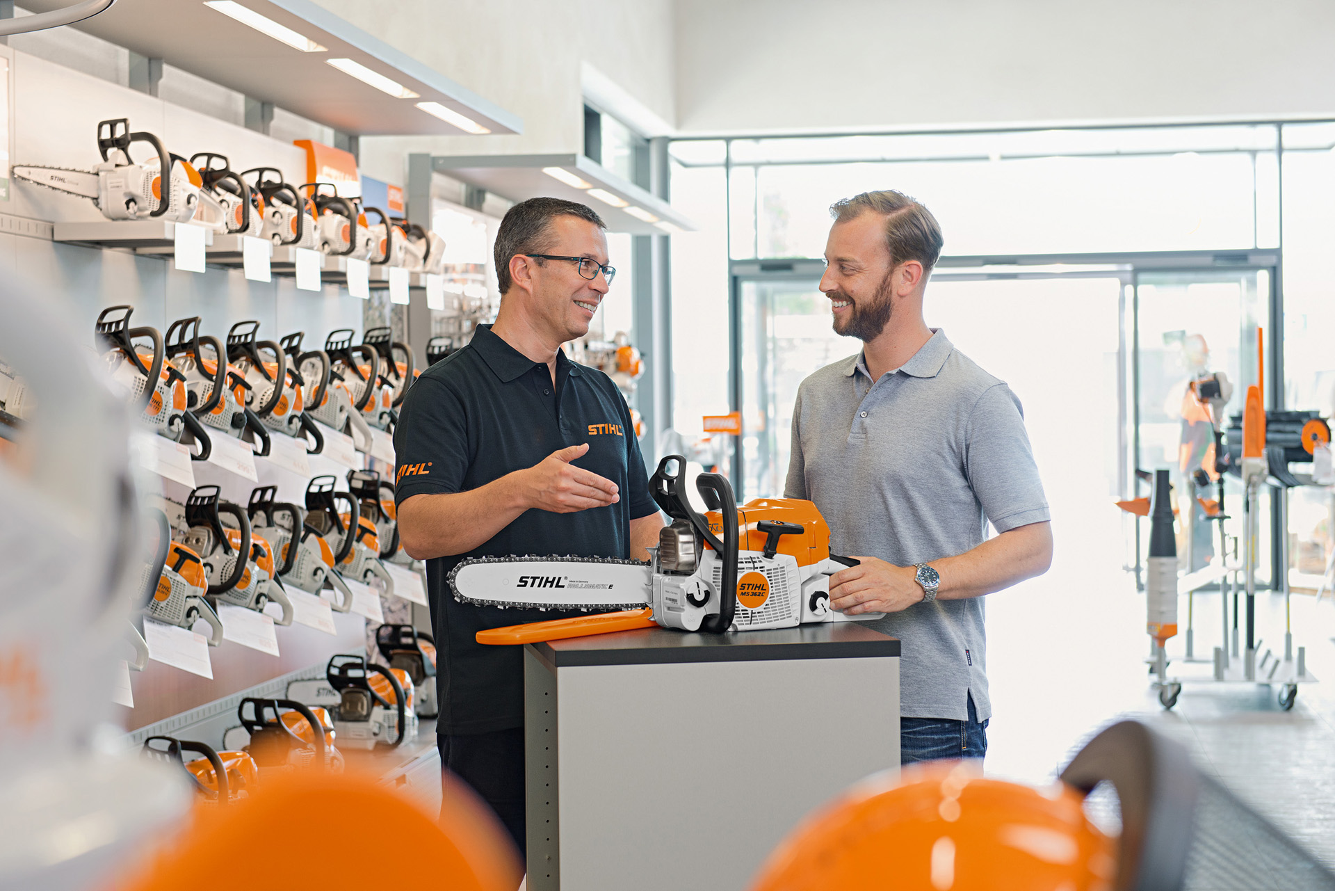 Дилер на STIHL му помага на купувач кој купува моторна пила STIHL