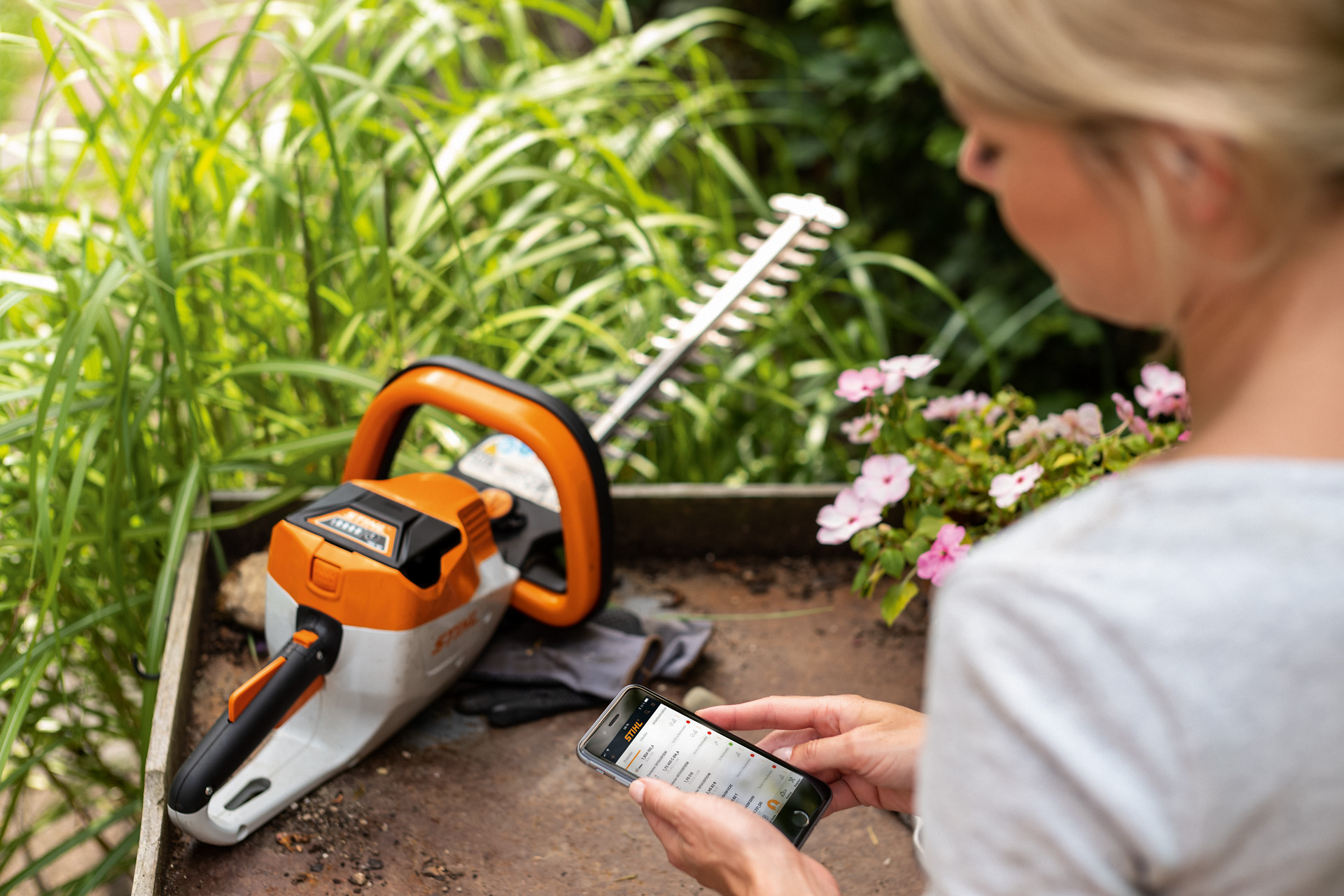 Жена ја регистрира својата STIHL тримерка за жива ограда користејќи ја апликацијата STIHL на паметен телефон