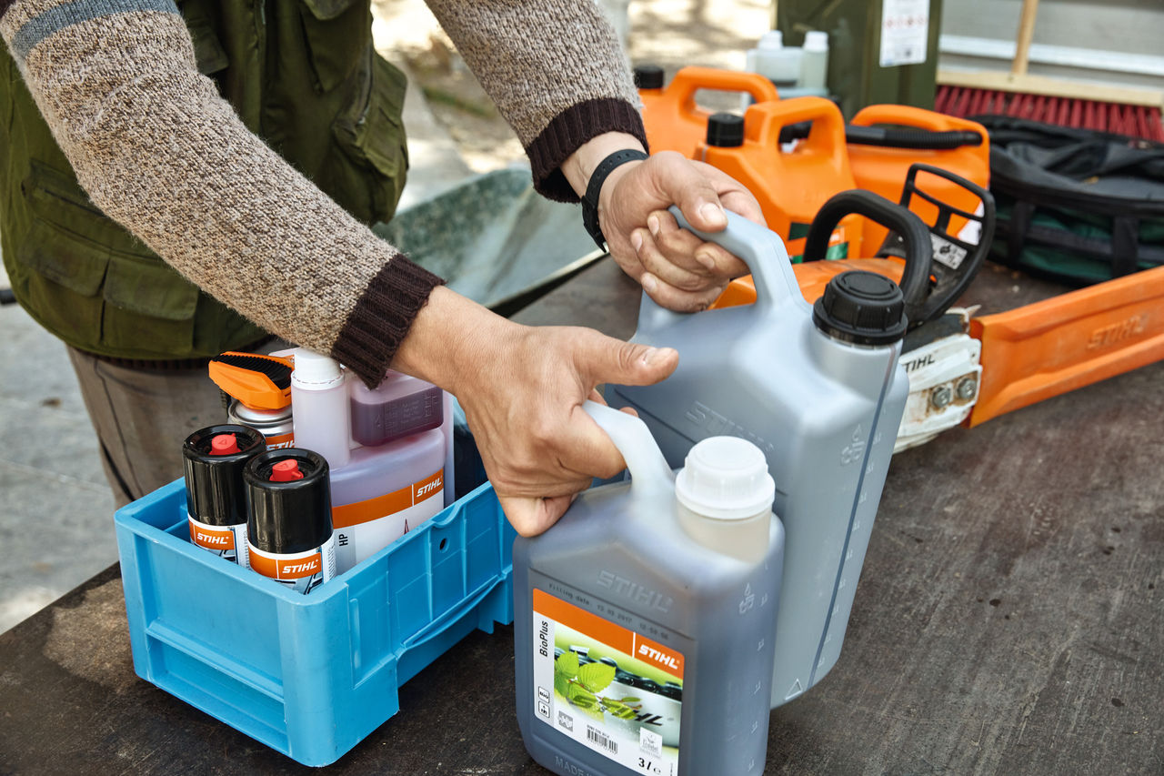 Лице кое ги средува горивата и мазивата STIHL во гајби за транспорт 
