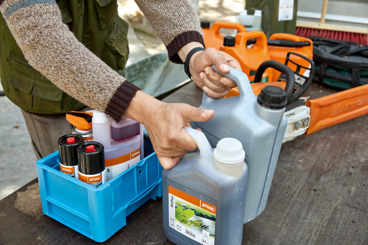 Лице кое ги средува горивата и мазивата STIHL во гајби за транспорт
