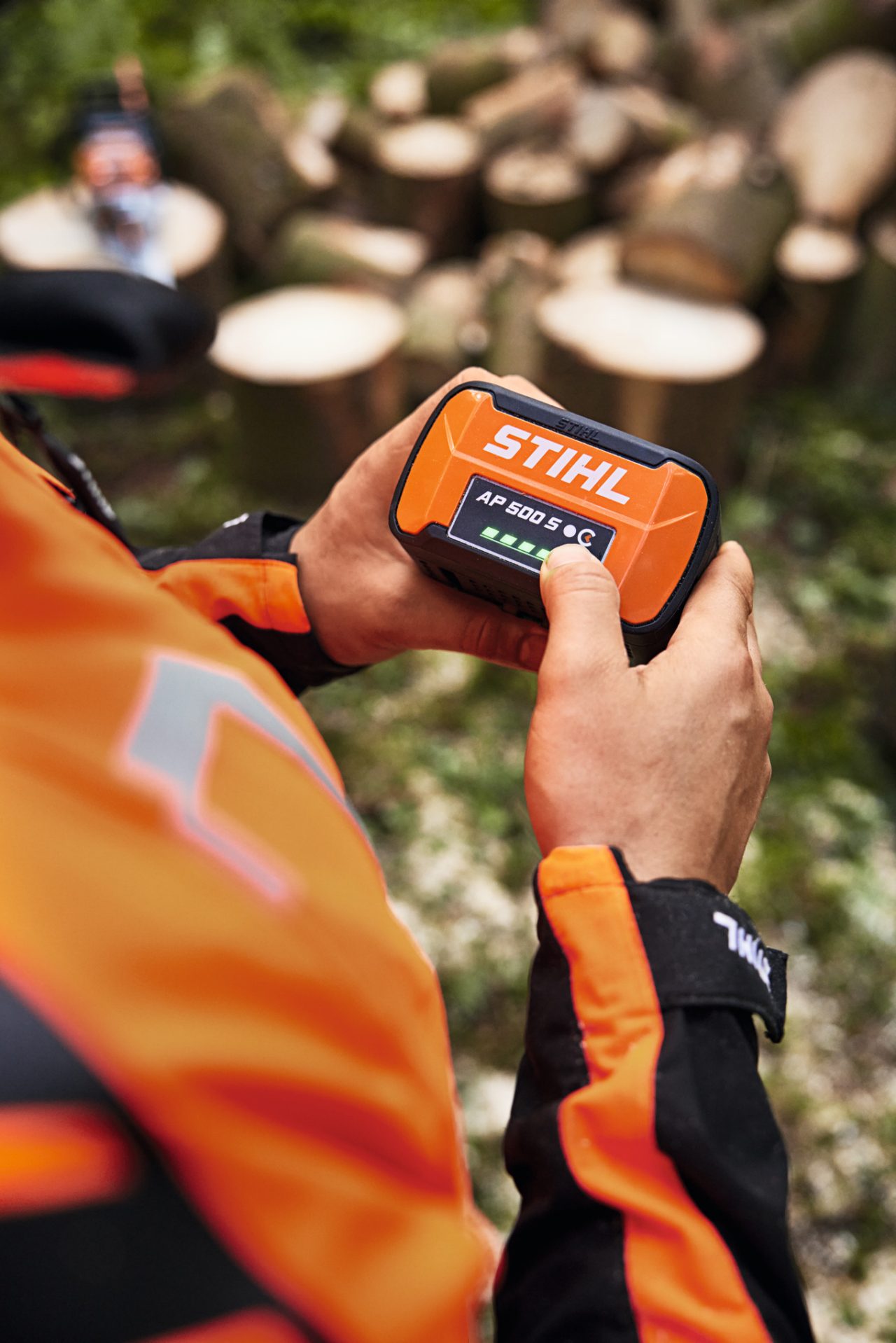 Крупен план на некој што сече низ стебло на дрво со батериската моторна пила STIHL MSA 300
