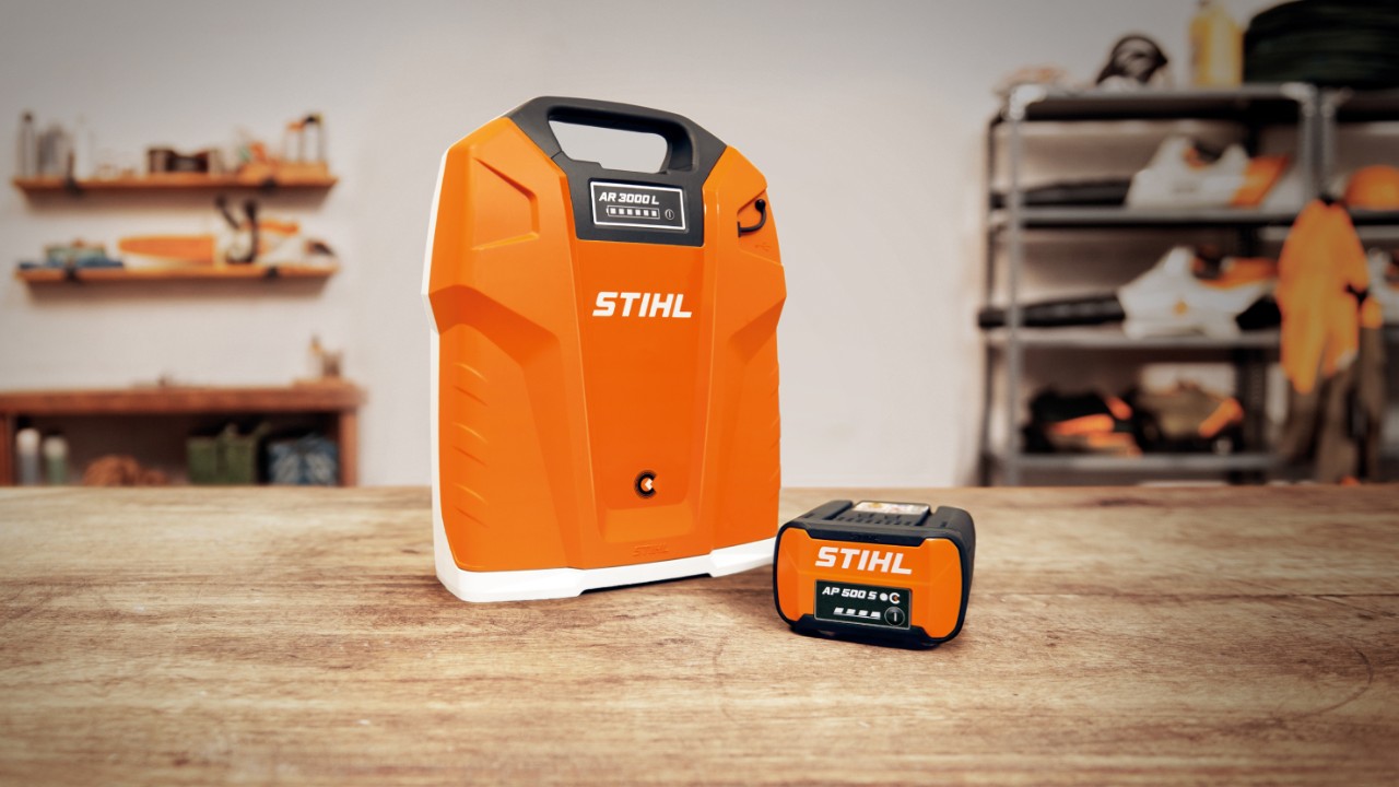 Работилница со рачна батерија STIHL AR 3000 L и батерија STIHL AP 500 S на дрвена маса  