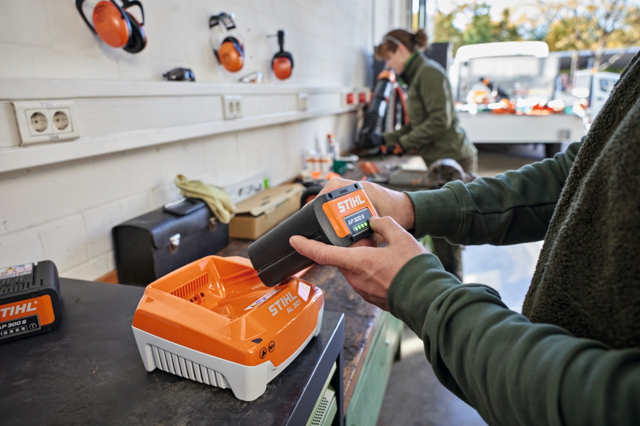 Едно лице става батерија STIHL AP 300 S во брзиот полнач STIHL AL 301