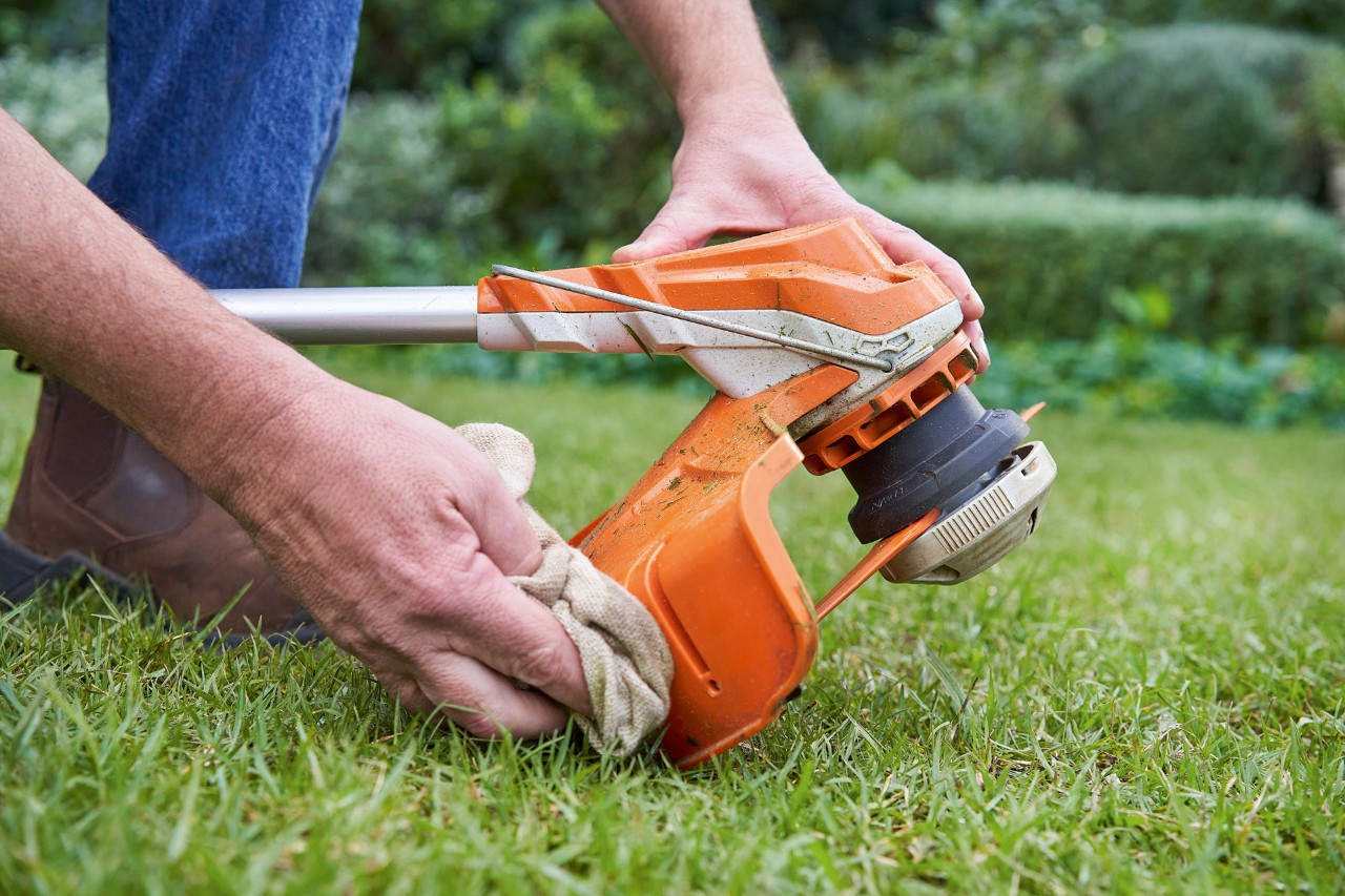 Лице кое го чисти штитникот на косата за грмушки STIHL со влажна крпа