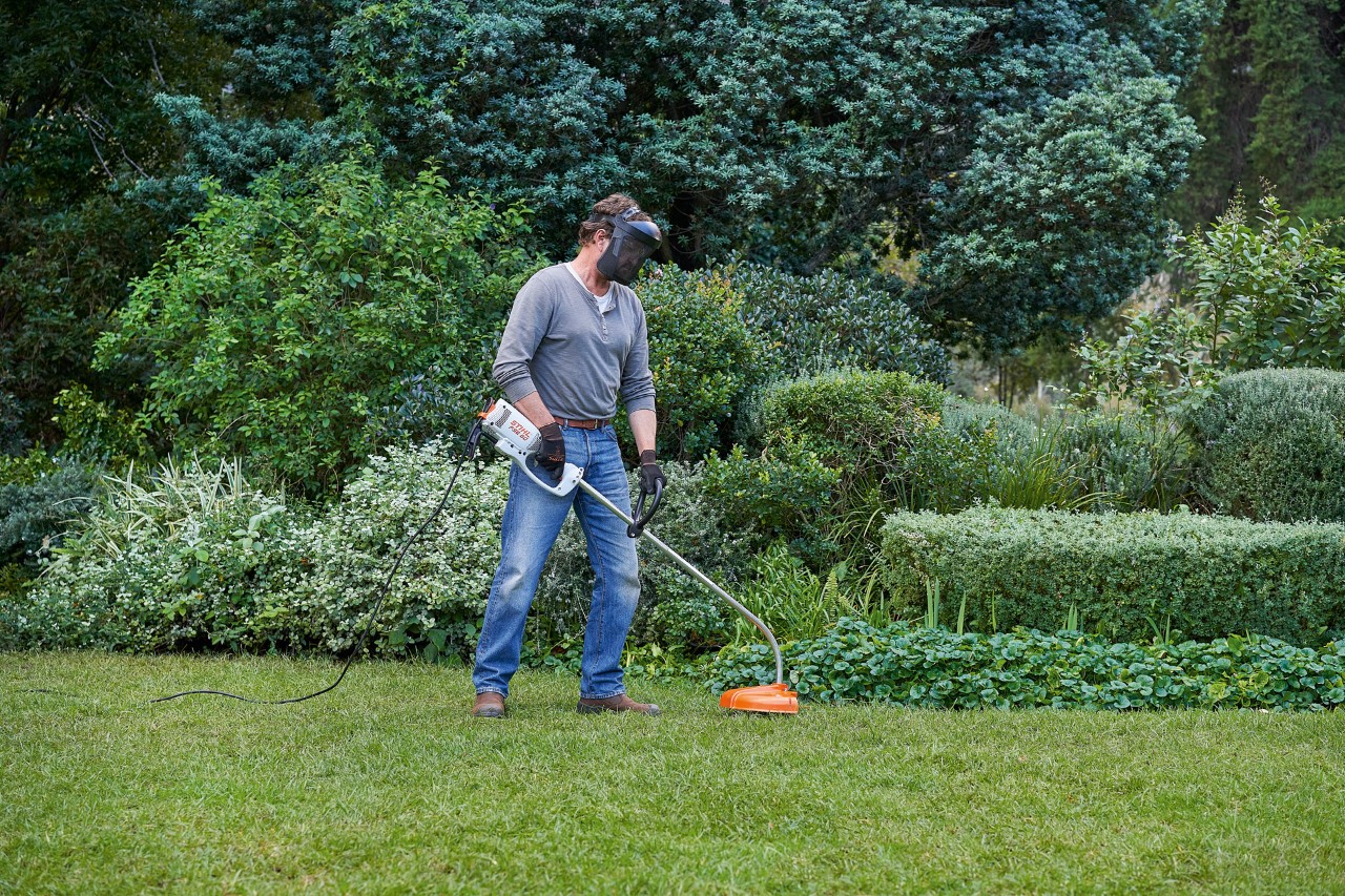 Човек со електрична коса за грмушки STIHL FSE 60 зазема сигурна положба на нозе