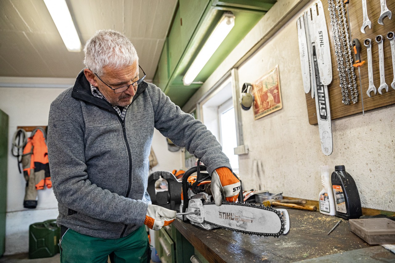 Лице во процес на затегнување на ланец од моторна пила STIHL во работилница